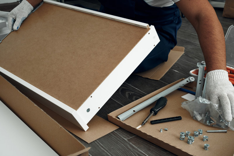 Handyman assembling flat-pack furniture in a Mayfair flat